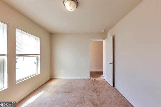 empty room with light carpet and baseboards