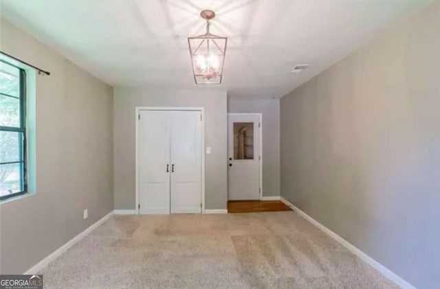 interior space featuring a chandelier and light colored carpet