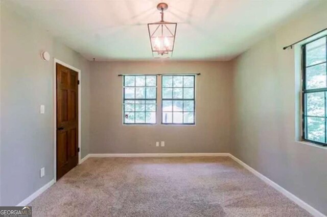 carpeted spare room featuring plenty of natural light