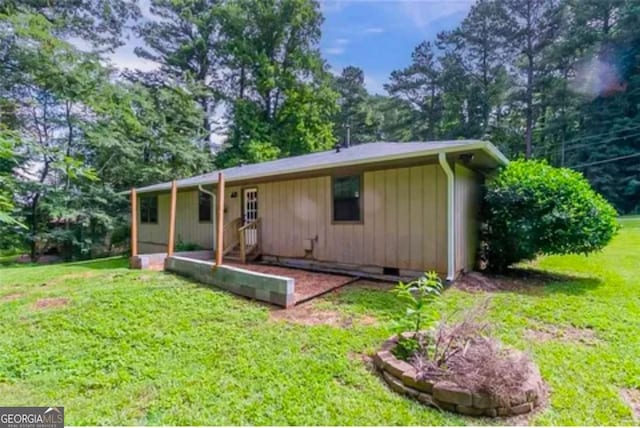 rear view of property featuring a lawn