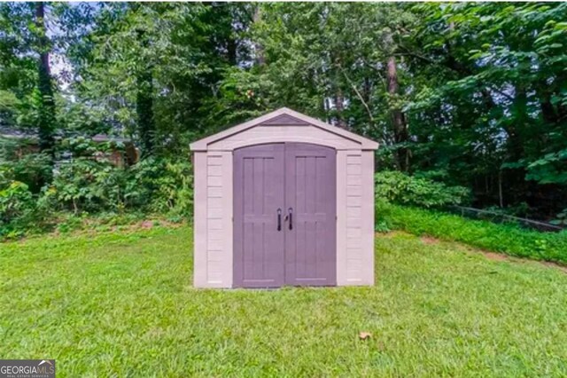 view of outbuilding featuring a lawn