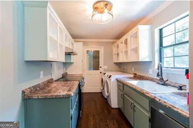 kitchen with appliances with stainless steel finishes, washing machine and dryer, ornamental molding, white cabinets, and sink