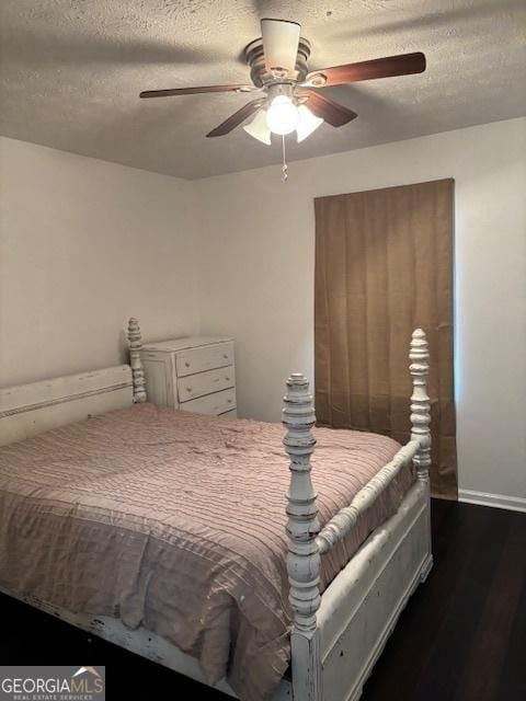 bedroom featuring a textured ceiling, ceiling fan, and dark wood-type flooring