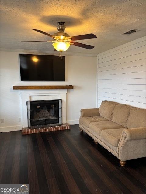 living room featuring a textured ceiling, dark wood-type flooring, and ceiling fan