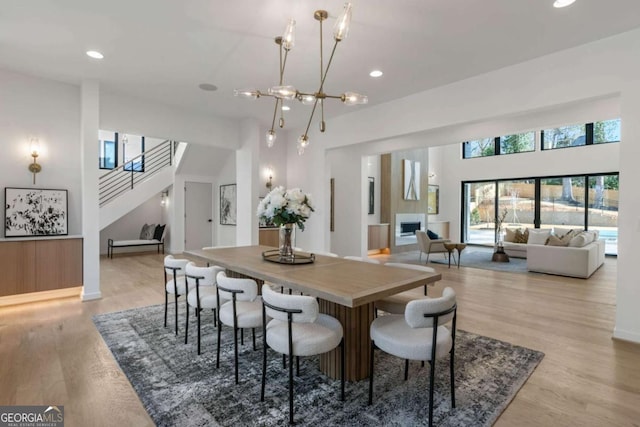 dining space with a high ceiling and light wood-type flooring