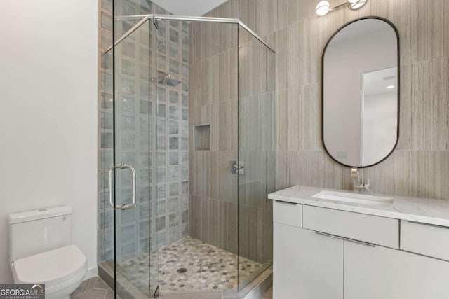 bathroom with toilet, vanity, and an enclosed shower