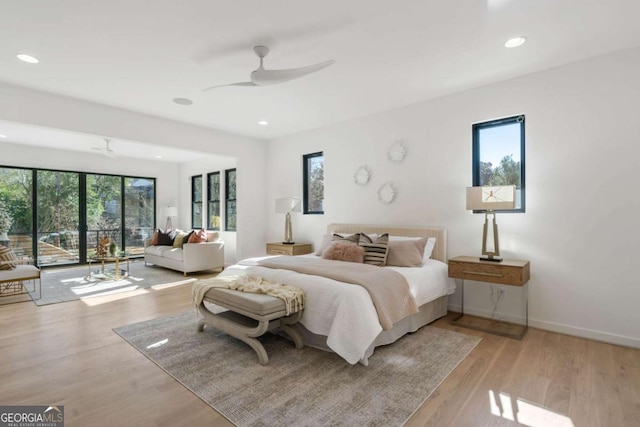 bedroom featuring ceiling fan, access to exterior, multiple windows, and light hardwood / wood-style floors