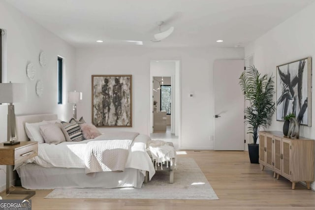 bedroom with ensuite bathroom and light hardwood / wood-style flooring