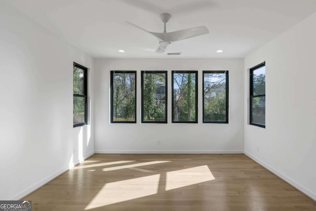 empty room with ceiling fan and light hardwood / wood-style flooring