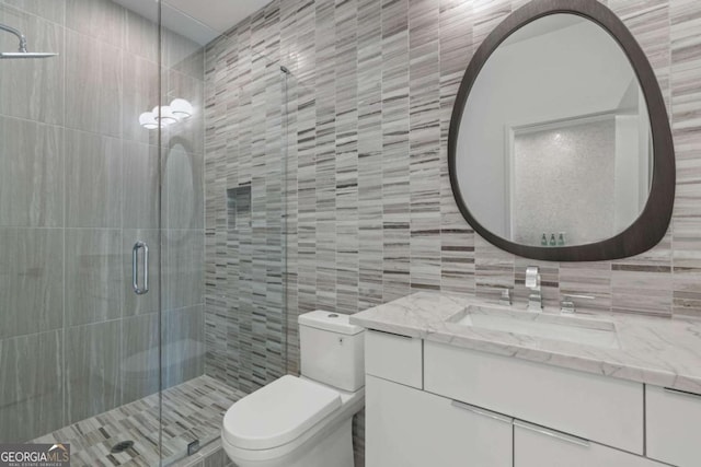 bathroom featuring tile walls, an enclosed shower, vanity, and toilet