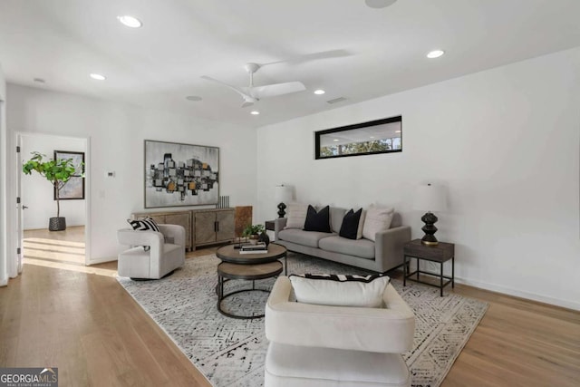 living room with ceiling fan and light wood-type flooring