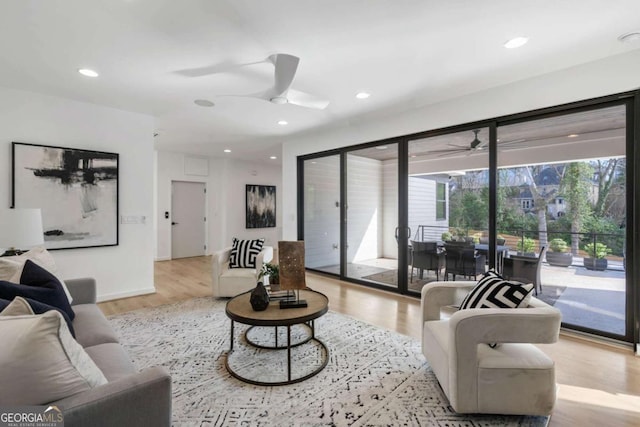 living room with ceiling fan and light hardwood / wood-style floors