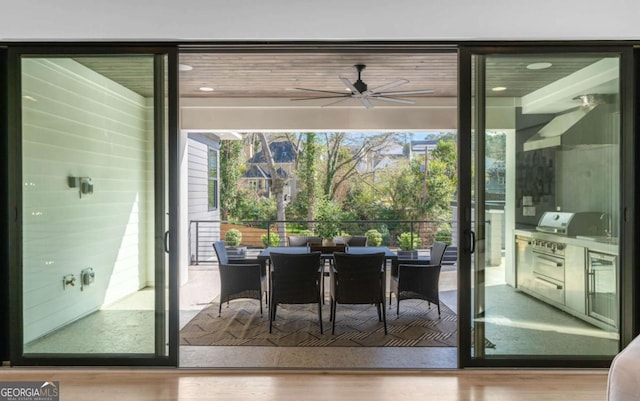 doorway featuring light wood-type flooring and ceiling fan