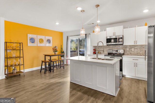 kitchen featuring sink, a center island with sink, white cabinets, and appliances with stainless steel finishes