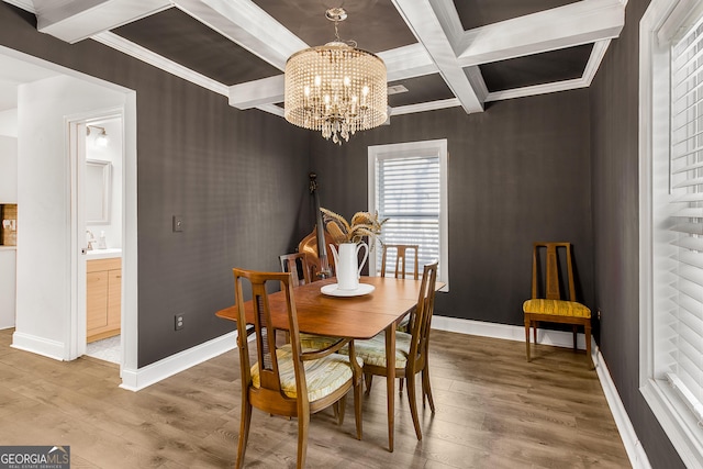 dining room featuring crown molding, hardwood / wood-style floors, coffered ceiling, a chandelier, and beamed ceiling