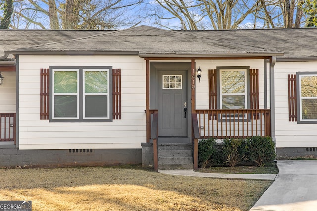 view of exterior entry with a yard