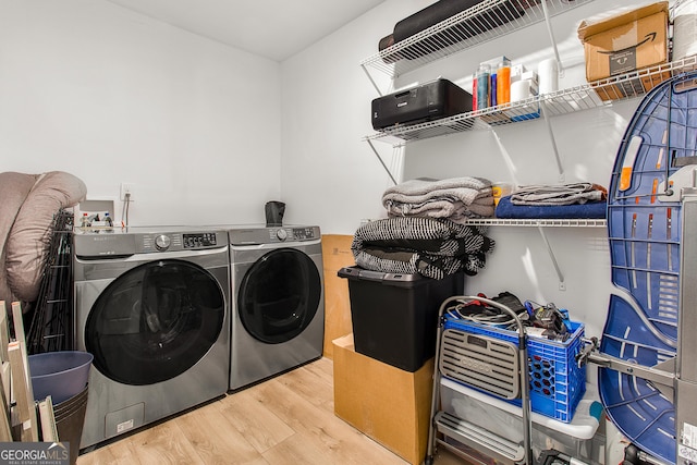 laundry room with light hardwood / wood-style floors and washer and clothes dryer