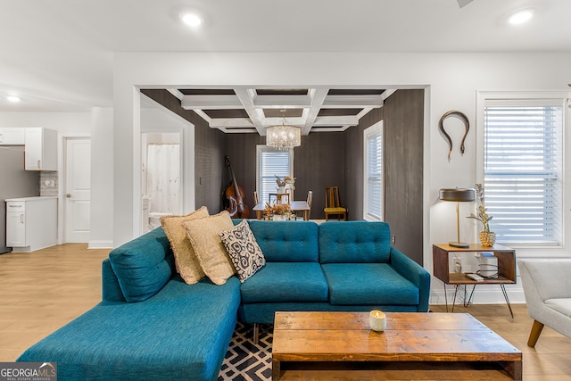 living room with coffered ceiling, beamed ceiling, light hardwood / wood-style flooring, and an inviting chandelier