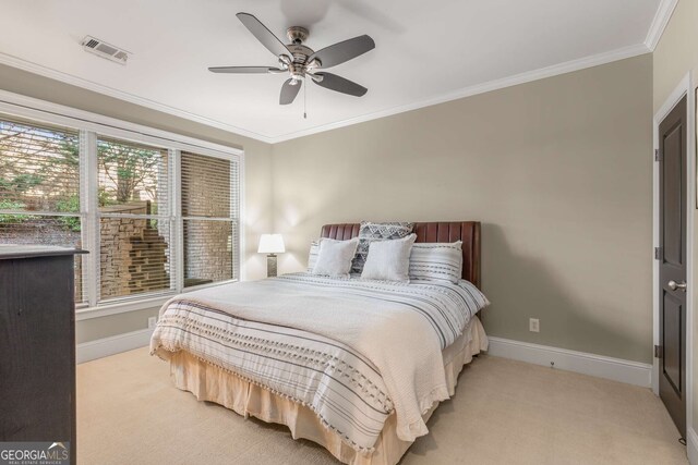 bedroom featuring ceiling fan, ensuite bathroom, and crown molding