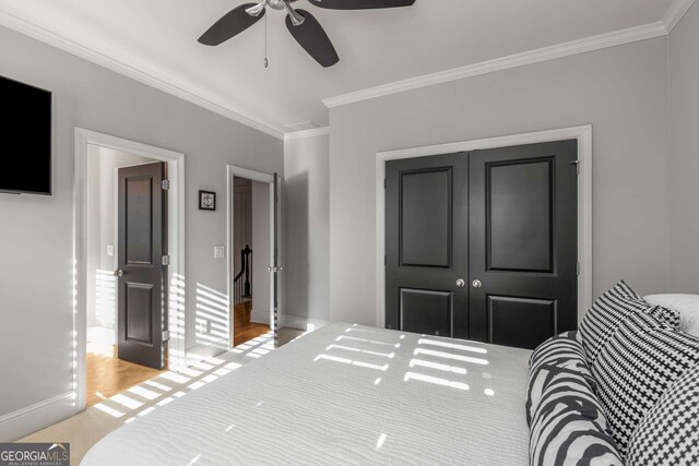 carpeted bedroom featuring ceiling fan, crown molding, and a tray ceiling