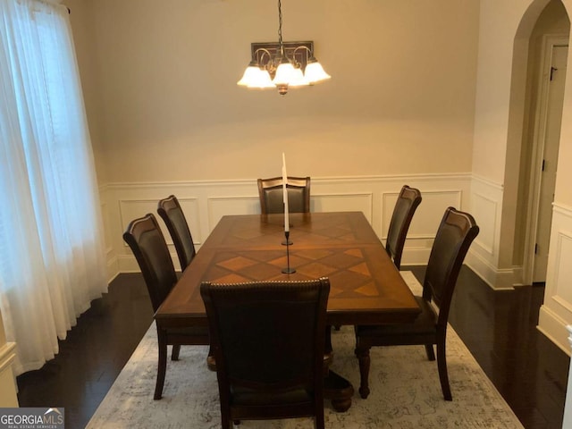 dining space featuring hardwood / wood-style floors and a notable chandelier