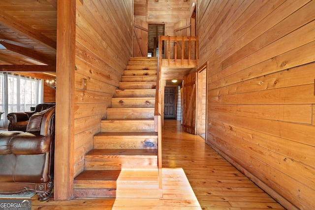 stairway featuring wooden walls and hardwood / wood-style flooring