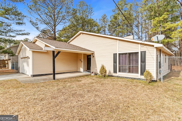 rear view of property with a garage and a yard