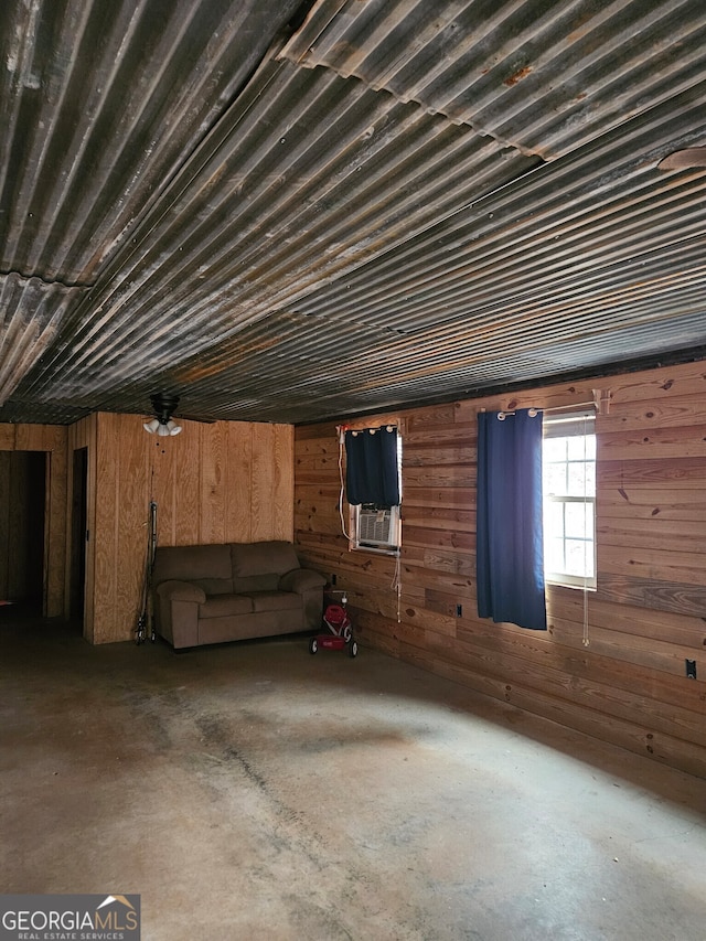 basement with ceiling fan, cooling unit, and wooden walls