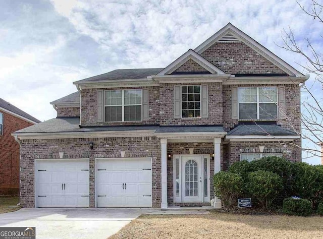 view of front facade featuring a garage, driveway, and brick siding