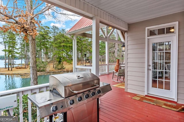 deck with a water view and a grill