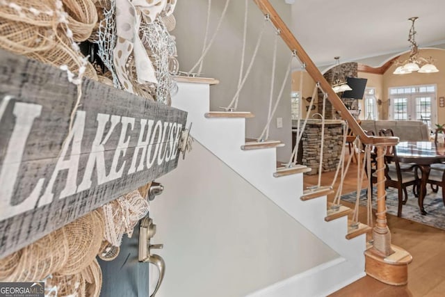 stairs featuring french doors, hardwood / wood-style flooring, and a notable chandelier