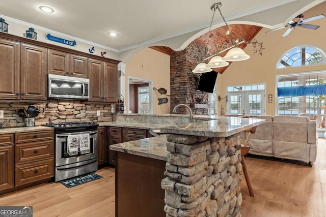 kitchen featuring appliances with stainless steel finishes, sink, a kitchen breakfast bar, hanging light fixtures, and kitchen peninsula