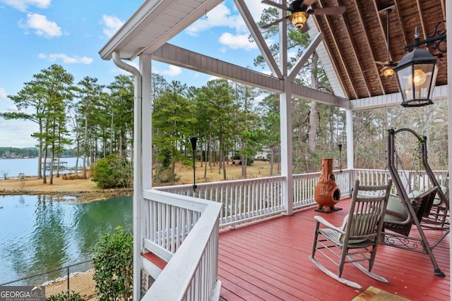 deck featuring ceiling fan and a water view