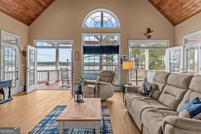 living room with high vaulted ceiling, wood ceiling, a water view, and light wood-type flooring