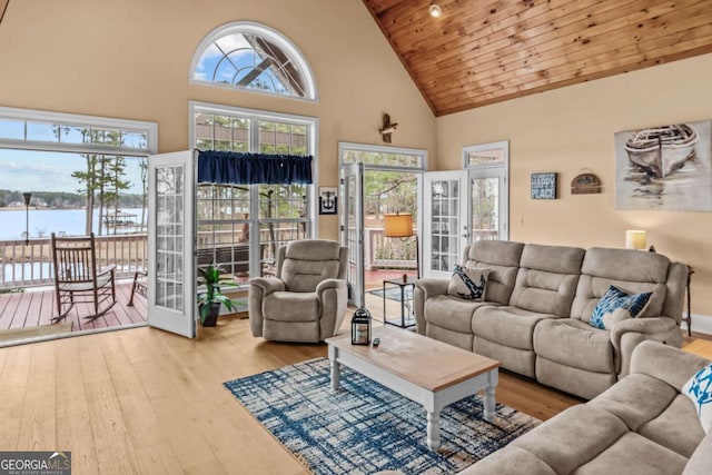 living room with wood ceiling, a water view, light hardwood / wood-style flooring, and high vaulted ceiling