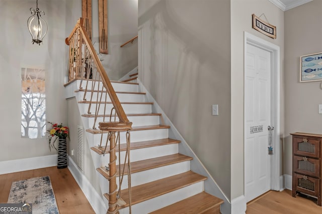 163 NE Knight Dr, Milledgeville, GA 31061 - stairs featuring wood finished floors, crown molding, and baseboards