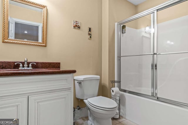 full bathroom with tile patterned floors, enclosed tub / shower combo, vanity, and toilet