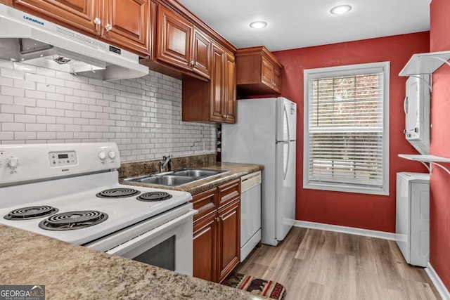 kitchen with tasteful backsplash, light hardwood / wood-style floors, washer / clothes dryer, sink, and white appliances