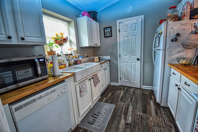 kitchen with wood counters, dishwasher, white cabinets, and fridge