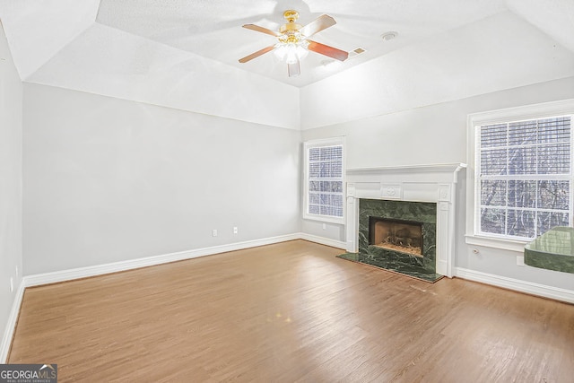 unfurnished living room with lofted ceiling, a fireplace, wood-type flooring, and ceiling fan