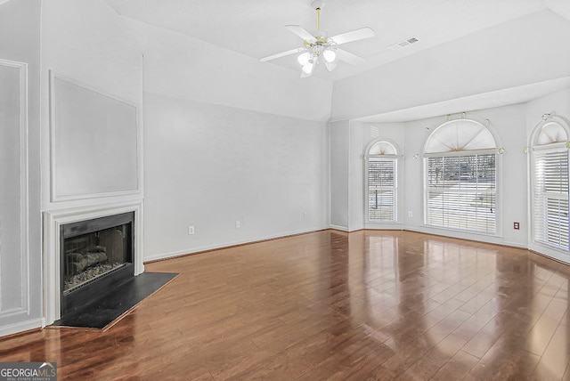 unfurnished living room featuring hardwood / wood-style flooring, ceiling fan, and vaulted ceiling