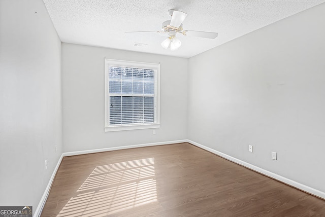 spare room featuring hardwood / wood-style flooring, ceiling fan, and a textured ceiling