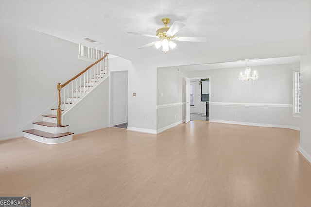 unfurnished living room featuring hardwood / wood-style flooring and ceiling fan with notable chandelier