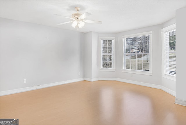 unfurnished room featuring ceiling fan, a healthy amount of sunlight, and hardwood / wood-style floors