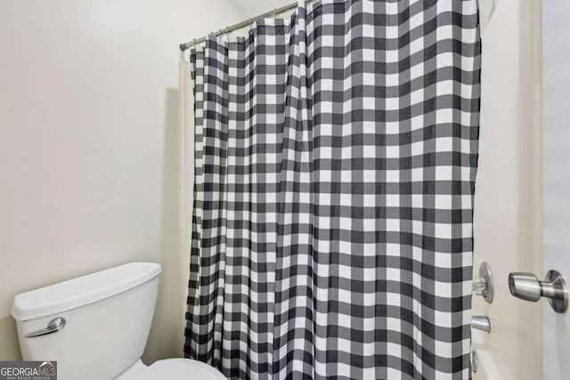 bathroom featuring toilet and a shower with shower curtain