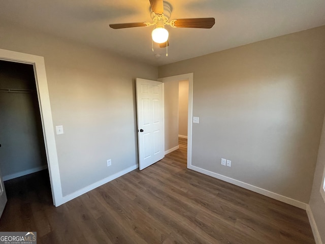 410 Hardy Ave SW, Rome, GA 30161 - unfurnished bedroom with a spacious closet, a closet, baseboards, and dark wood finished floors