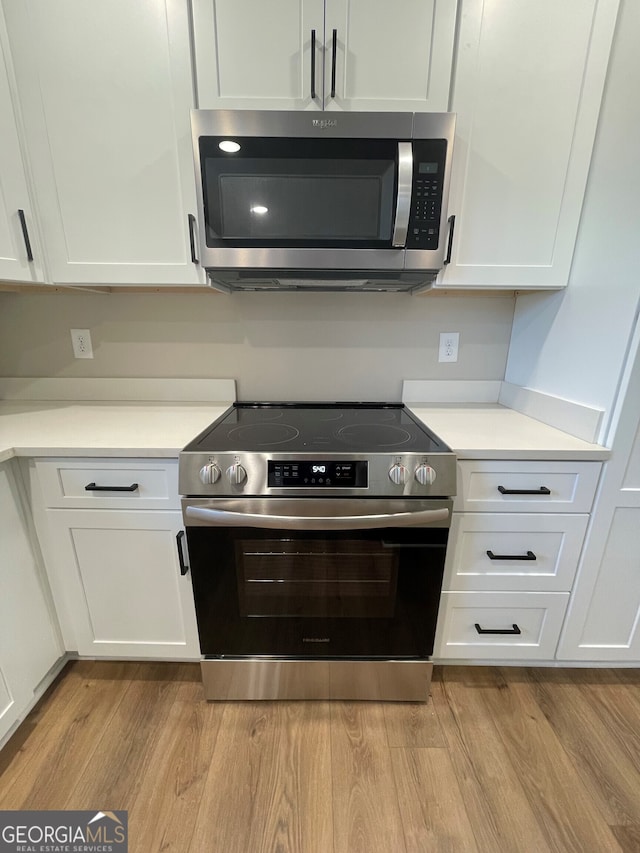 410 Hardy Ave SW, Rome, GA 30161 - kitchen featuring light wood finished floors, light countertops, white cabinetry, and stainless steel appliances
