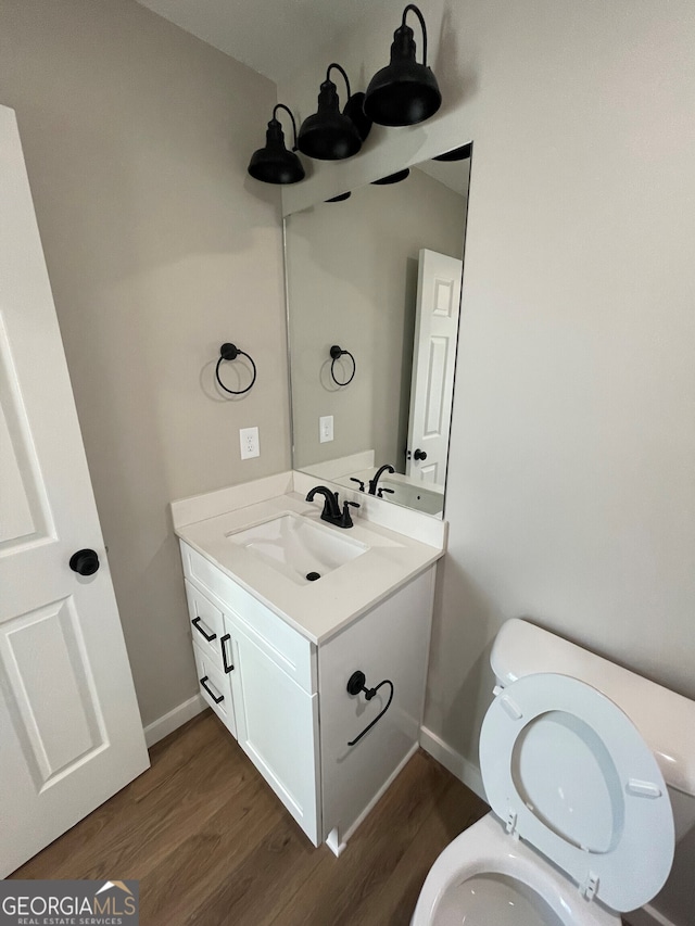 410 Hardy Ave SW, Rome, GA 30161 - bathroom with toilet, vanity, wood finished floors, and baseboards