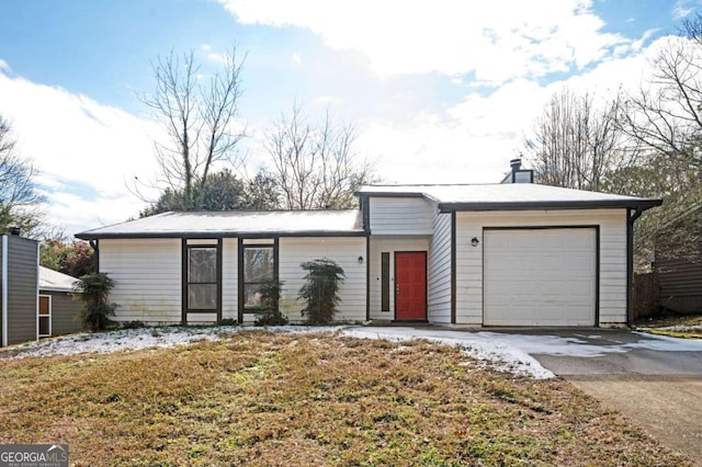 single story home with a front yard and a garage