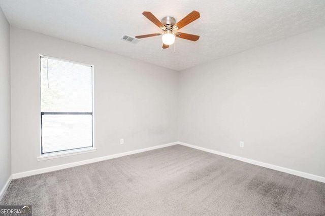 spare room with a textured ceiling, ceiling fan, and carpet floors